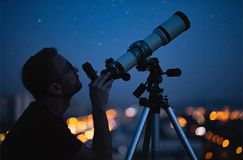 Un homme regarde le ciel avec son télescope