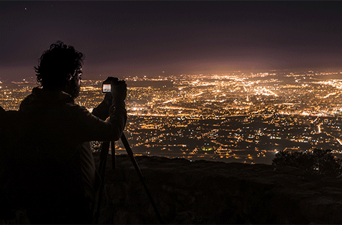 Un homme prend en photo la ville depuis un point en hauteur