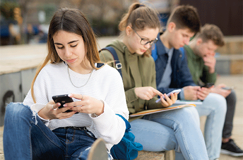 Des adolescents qui utilisent leur smartphone