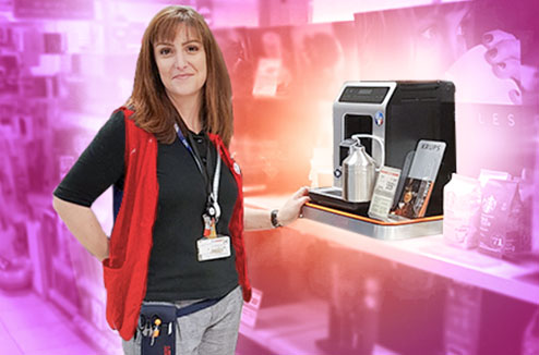 Vendeuse Darty debout à côté d'une machine à café avec broyeur