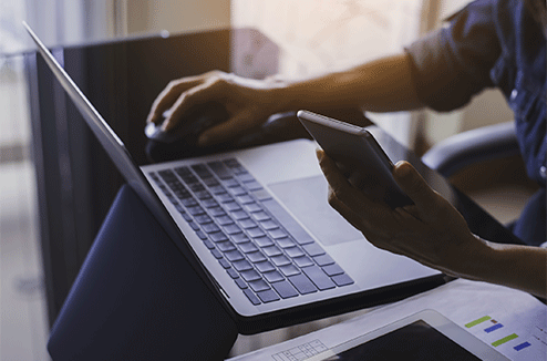 Une femme sur son ordinateur et son portable