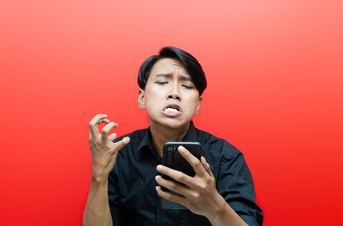 homme s'énervant après son smartphone