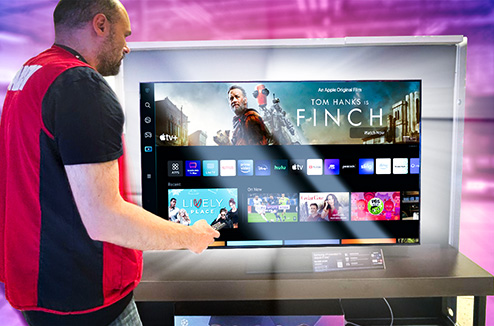 Les Smart TV donnent accès à tous vos conteus sur une meme interface Vendeur Darty navigant dans une interface de smart TV