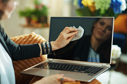 Le nettoyage des écrans de vos appareils est crucial Une femme nettoie son écran de PC portable