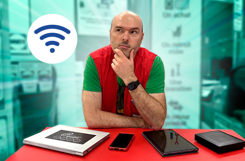 Le wifi a connu de nombreuses évolutions depuis son lancement Vendeur Darty dubitatif devant une table avec differents appareils numériques