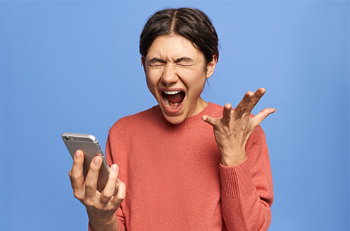 Marre des démarchages téléphoniques ? Une femme en colère devant son téléphone
