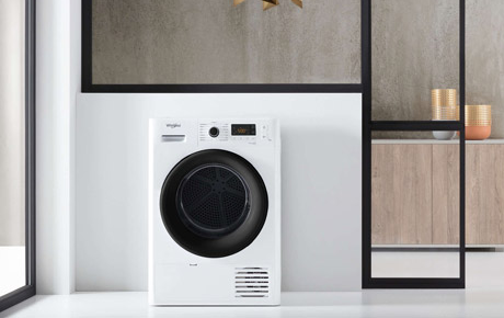 Un sèche linge blanc à porte noire dans une buanderie moderne