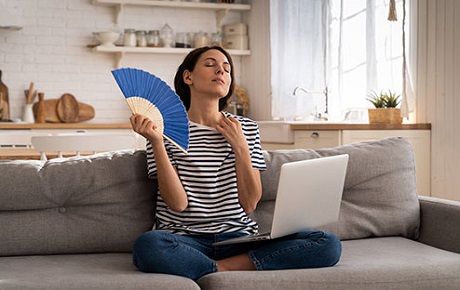 Jeune femme assise se ventile avec un éventail