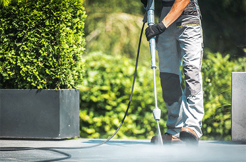 Une personne utilise son karcher sur le sol