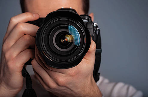 Un homme qui tient un appareil photo