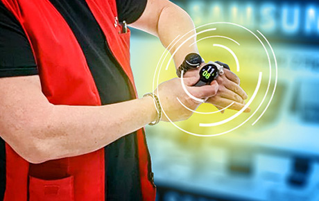 Un vendeur Darty en train d'appuyer sur une montre connectée à son poignet