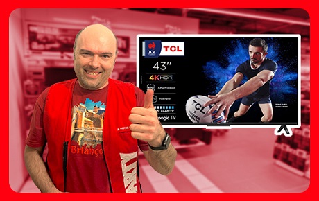 Un vendeur Darty fait le signe OK à côté d'un TV 4K TCL