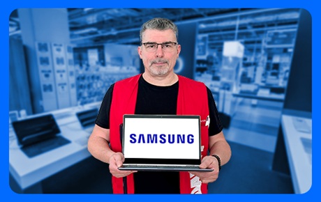 Un vendeur Darty tient un pc portable Samsung devant lui