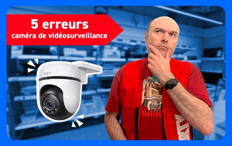 Un vendeur Darty prend un air dubitatif à côté d'une caméra de surveillance