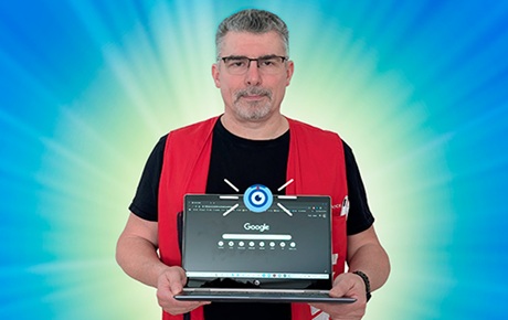 Un vendeur Darty tient un pc portable dont la webcam affiche un oeil indiscret