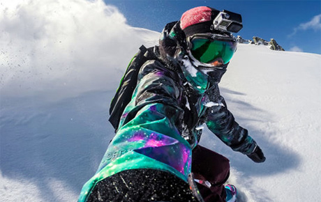 Une personne faisant du snowboard avec une caméra sport sur la tête