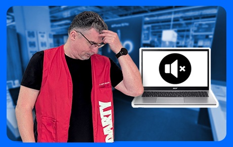 Un vendeur Darty l'air pensif à côté d'un pc portable affichant une icone de son