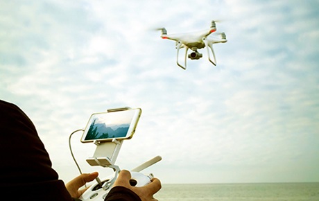 Un homme fait voler un drone sous un ciel couvert