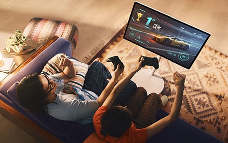 2 personnes assises sur un canapé jouent sur le Samsung Movingstyle