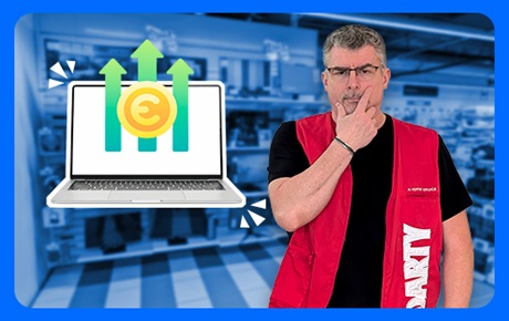 Un vendeur Darty dubitatif à côté d'un PC portable affichant des prix qui montent