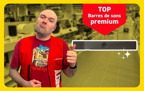 Un vendeur Darty fait le signe OK à côté d'une barre de son premium