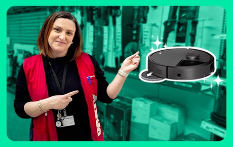 Une vendeuse Darty montre un aspirateur robot situé sur sa gauche