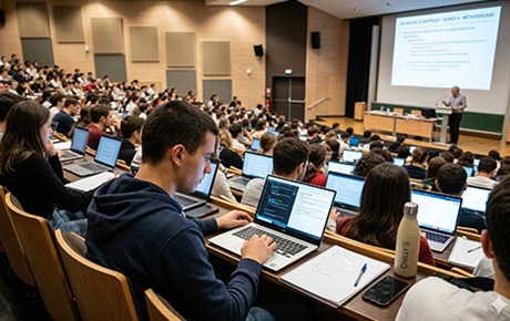 Des étudiants travaillent sur pc portable dans un amphithéatre