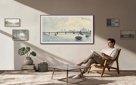 Un homme est assis dans son salon à côté d'un TV Samsung The Frame 2026