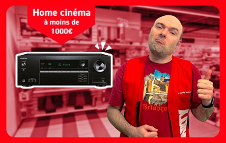 Un vendeur Darty fait le signe OK à côté d'un amplificateur home-cinéma