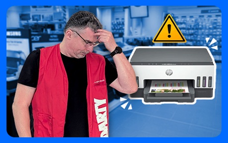 Un vendeur Darty se gratte la tête à côté d'une imprimante en panne