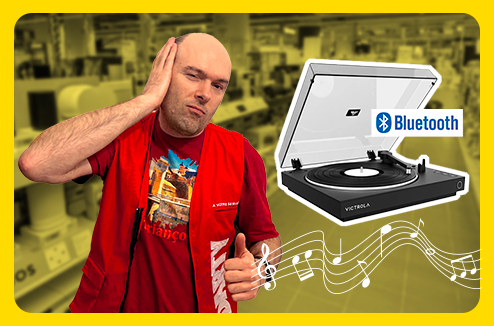 Un vendeur Darty se tient l'oreille à côté d'une platine vinyle