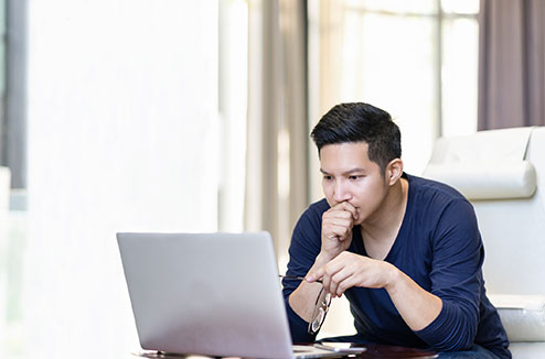 homme ennuyé devant un ordinateur