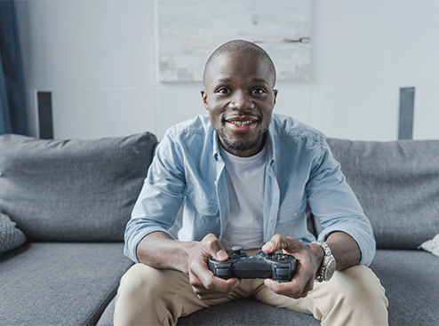 Un homme joue à la console avec une manette