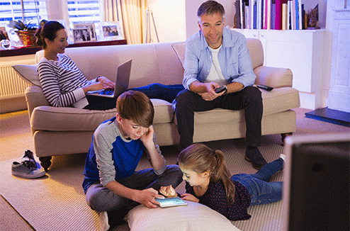 Une famille sur la télé et la tablette dans un salon