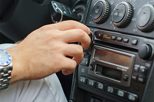 Une personne changeant de musique sur son autoradio
