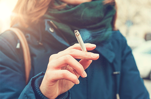 Une femme tenant une cigarette dans sa main 