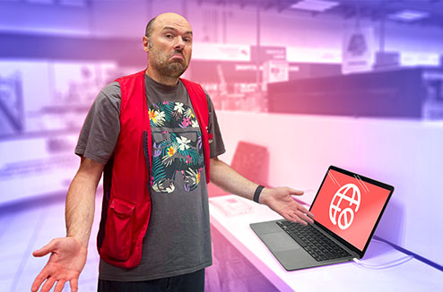 Vendeur Darty dubitatif devant un pc portable