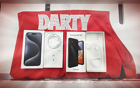 Un gilet de vendeur Darty avec une boite d'iPhone ouverte sur les accessoires