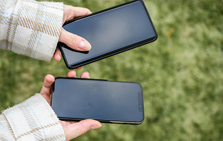 Une femme tenant deux smartphones