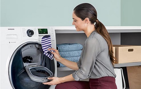 Jeune femme remplit son lave-linge