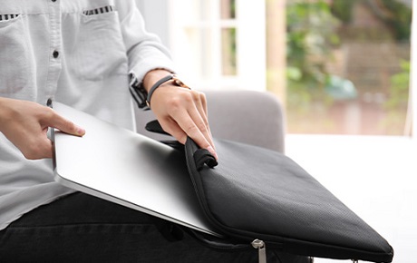 Un home range son pc portable dans sa housse