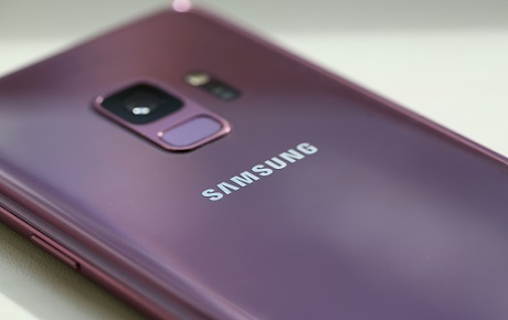 Vu du dos d'un smartphone Samsung violet posé sur une table blanche