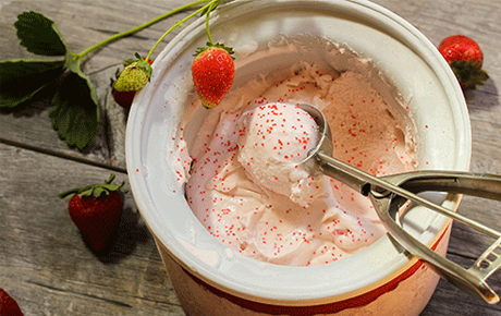 Une glace rose avec une cuillère à glace dedans